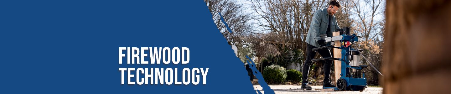 A man operates a log splitter machine outdoors. The machine is set up in a yard with trees and shrubs in the background.