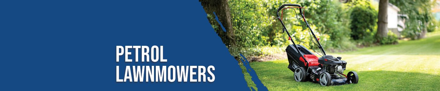 A Scheppach petrol lawnmower on a green lawn. Trees and bushes are visible in the background.