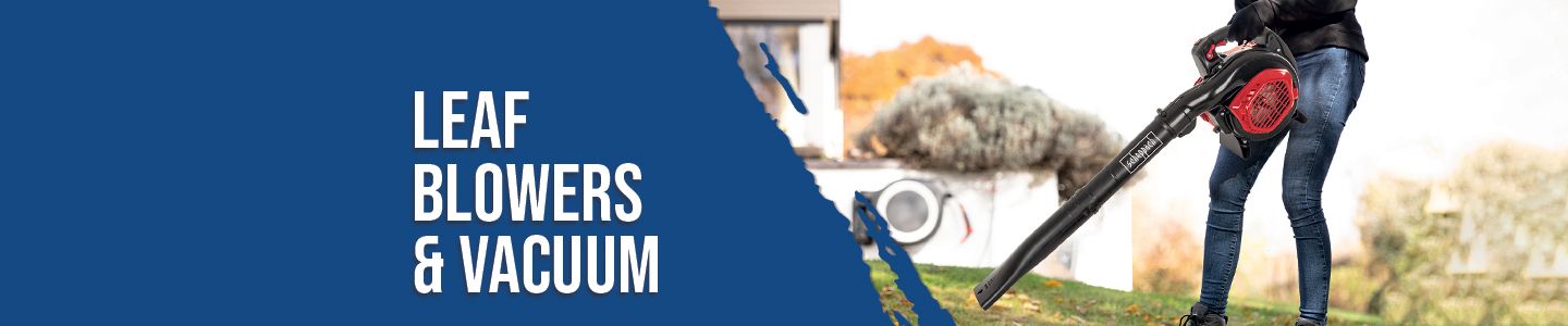 Person using a leaf blower outdoors. A house with a pile of leaves is visible in the background.