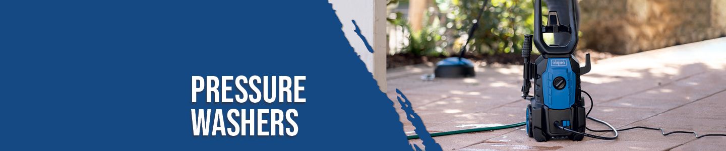 A Scheppach pressure washer on a terrace. The pressure washer is connected to a hose and stands on a paved floor. In the background, there are plants and a fence.