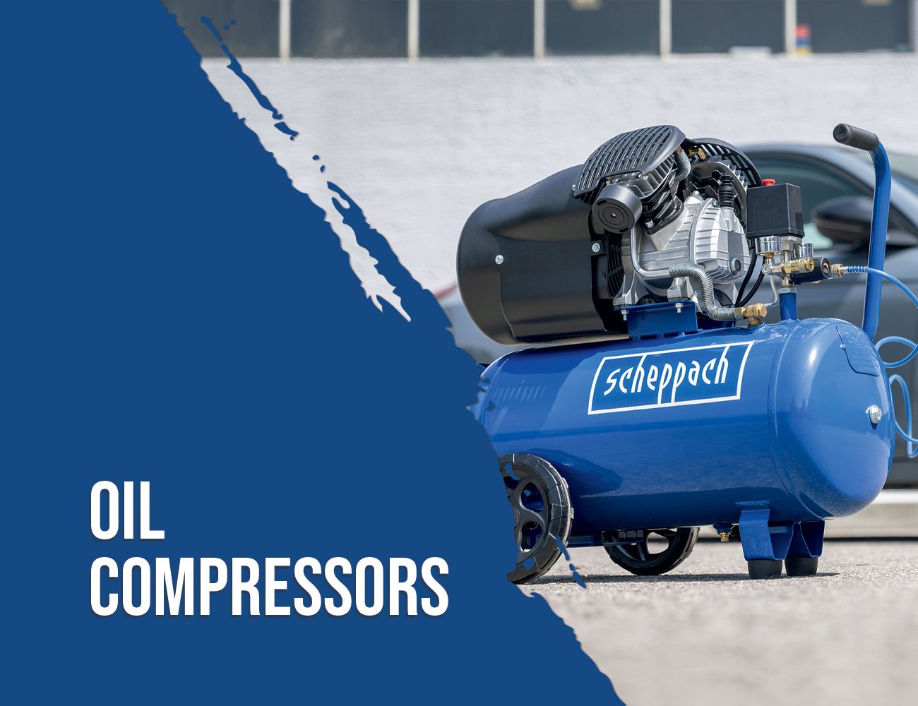 A Scheppach oil compressor on a parking lot. The compressor has a blue tank and a black motor.