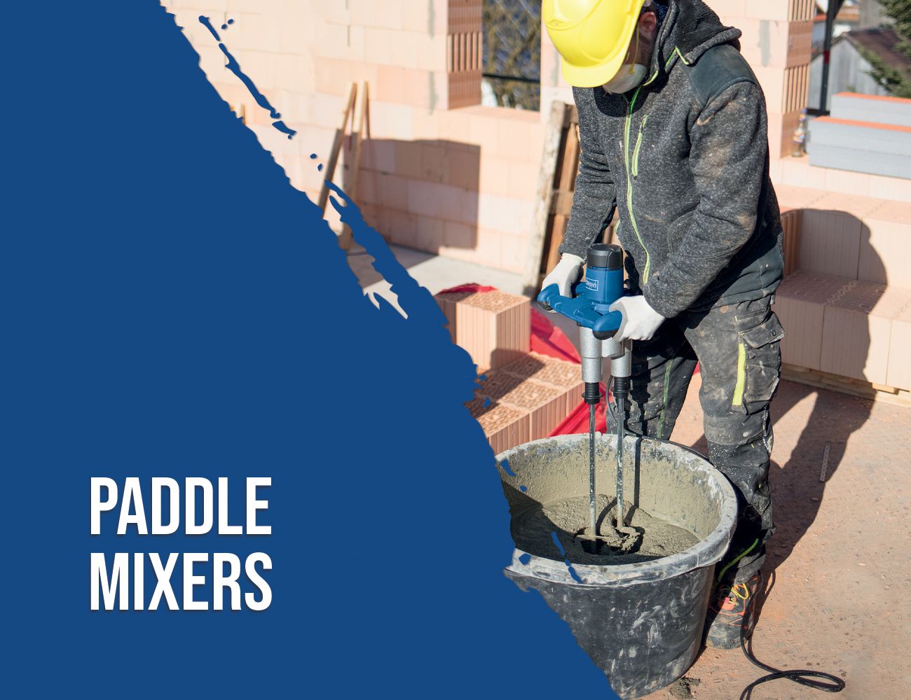 A worker uses a Scheppach paddle mixer to mix material in a bucket. The worker wears a yellow safety helmet and gloves.
