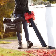 Person using Scheppach leaf blower with collection bag outdoors