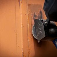 Scheppach metal wire brush in use on a surface