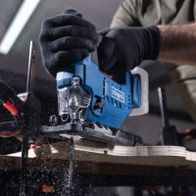 Cordless jigsaw with tool in use, close-up of cutting blade assembly