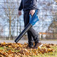 Person using a Scheppach cordless leaf blower with battery and charger