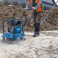 Scheppach vibrating plate with base and wheels in use on a work surface