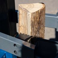 Scheppach metre log splitter showing a log piece between the clamp and blade