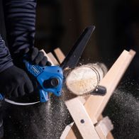 Scheppach cordless pruning saw BC-PS150-X cutting through wood logs during operation