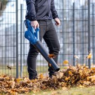 Person using a Scheppach cordless leaf blower with leaf collection attachment