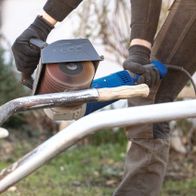 Person using an abrasive strap brush from Scheppach