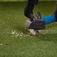 Scheppach plastic fiber brush in use on grass surface