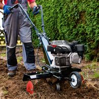 Scheppach motorized backhoe with engine and attachment, shown in use on ground