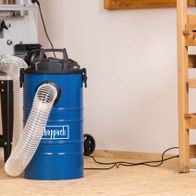 Scheppach dust extractor with connected suction hose and container in workshop setting