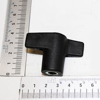 A black elbow connector with one straight and one angled end, next to a ruler for size reference. The elbow connector is approximately 3 cm long and 2 cm wide. The view shows the top of the elbow connector.
