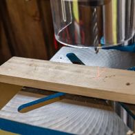 Scheppach bench pillar drill with laser guide, showing drill bit and workpiece clamp