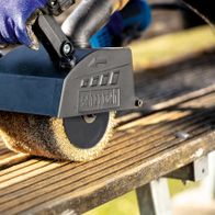 Scheppach metal wire brush in use on a machine. The brush is applied to wood.