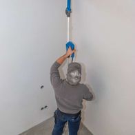 Wall sander with round and corner head in use, surface being worked on