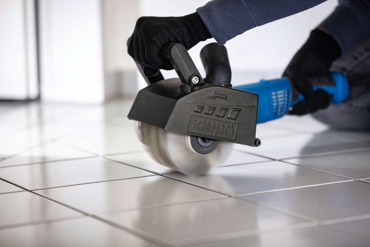 Scheppach plastic fiber brush in use, with control handle and protective gloves