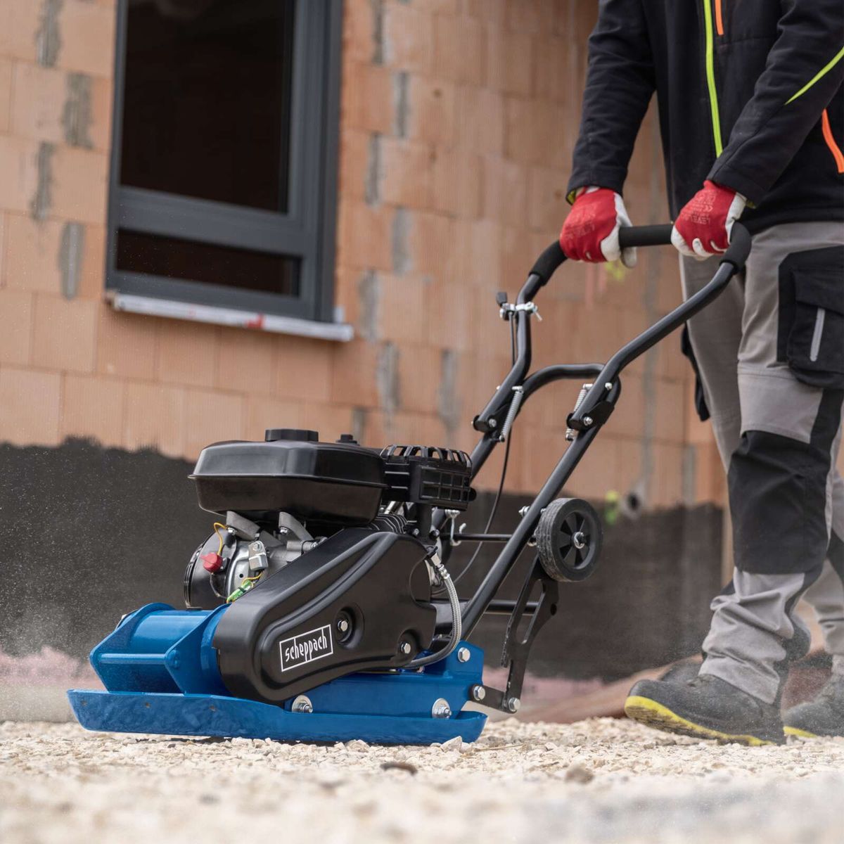 Scheppach vibrating plate compactor with engine and wheel assembly in use