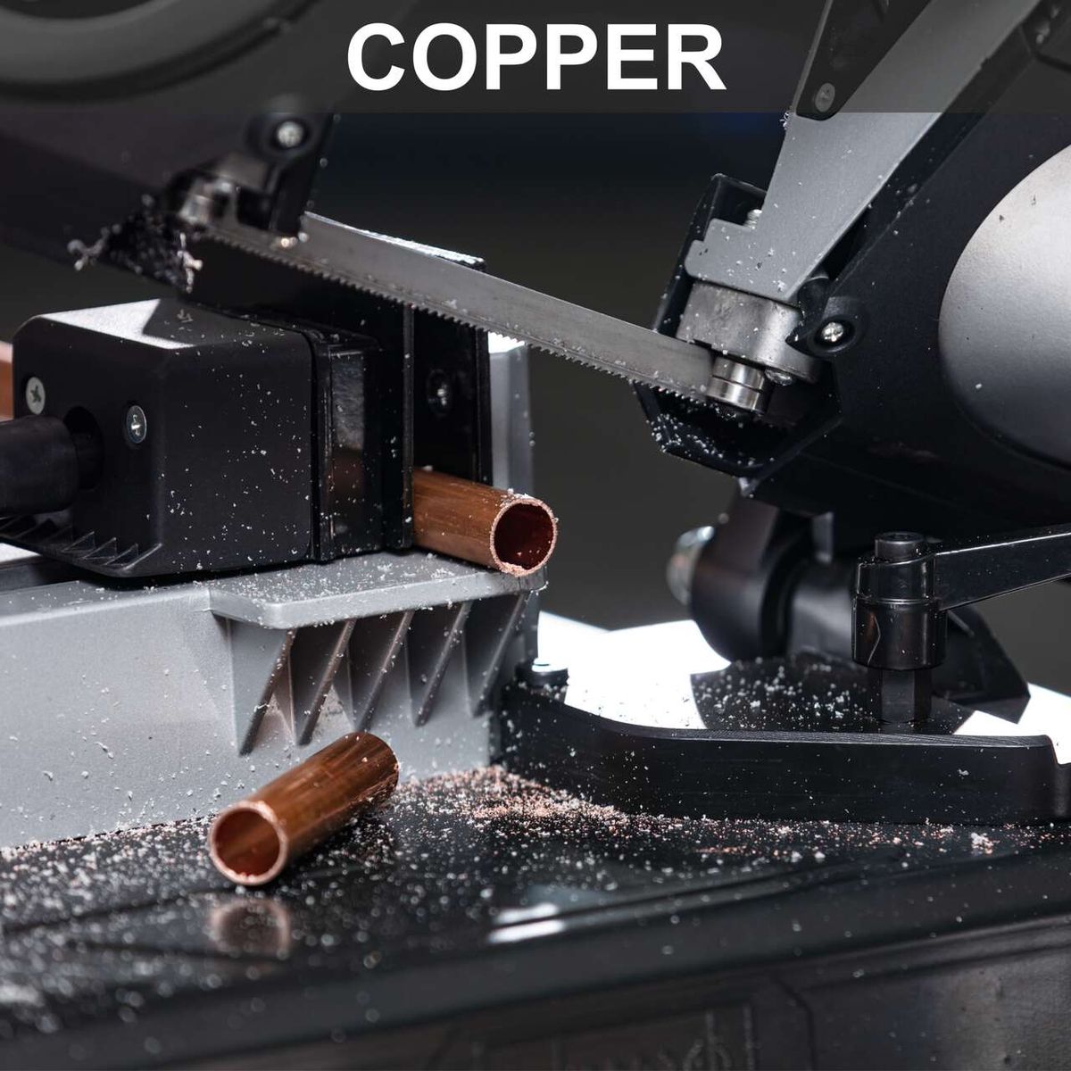 Metal band saw with worn copper band and saw blade in operation