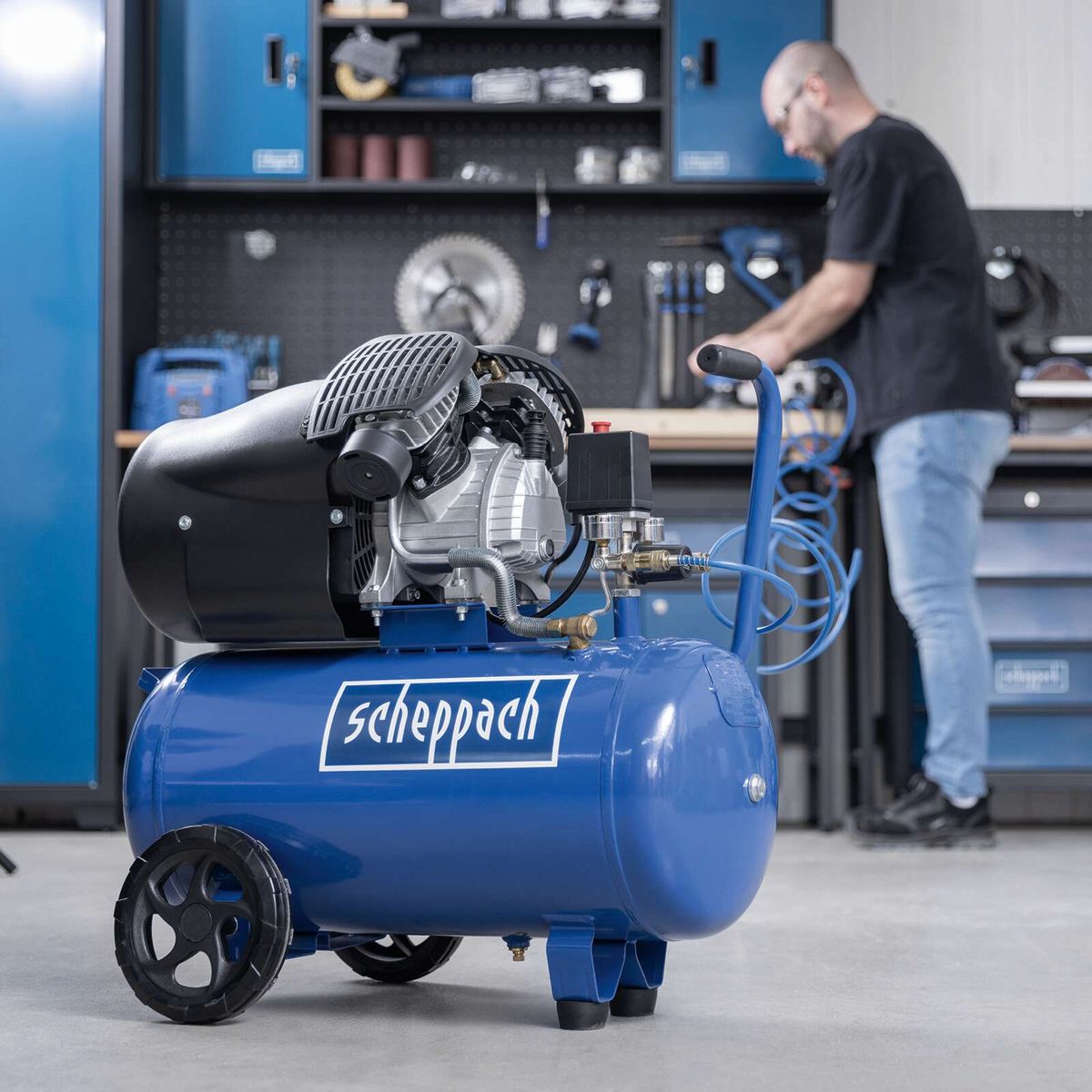 Scheppach air compressor with control elements and tool connection fittings, in workshop setting