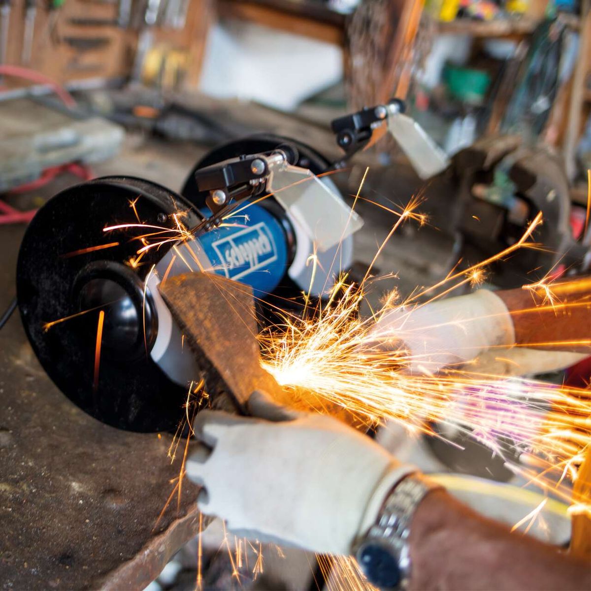 Scheppach bench grinder with LED lighting and dust collection, close-up with sparks flying