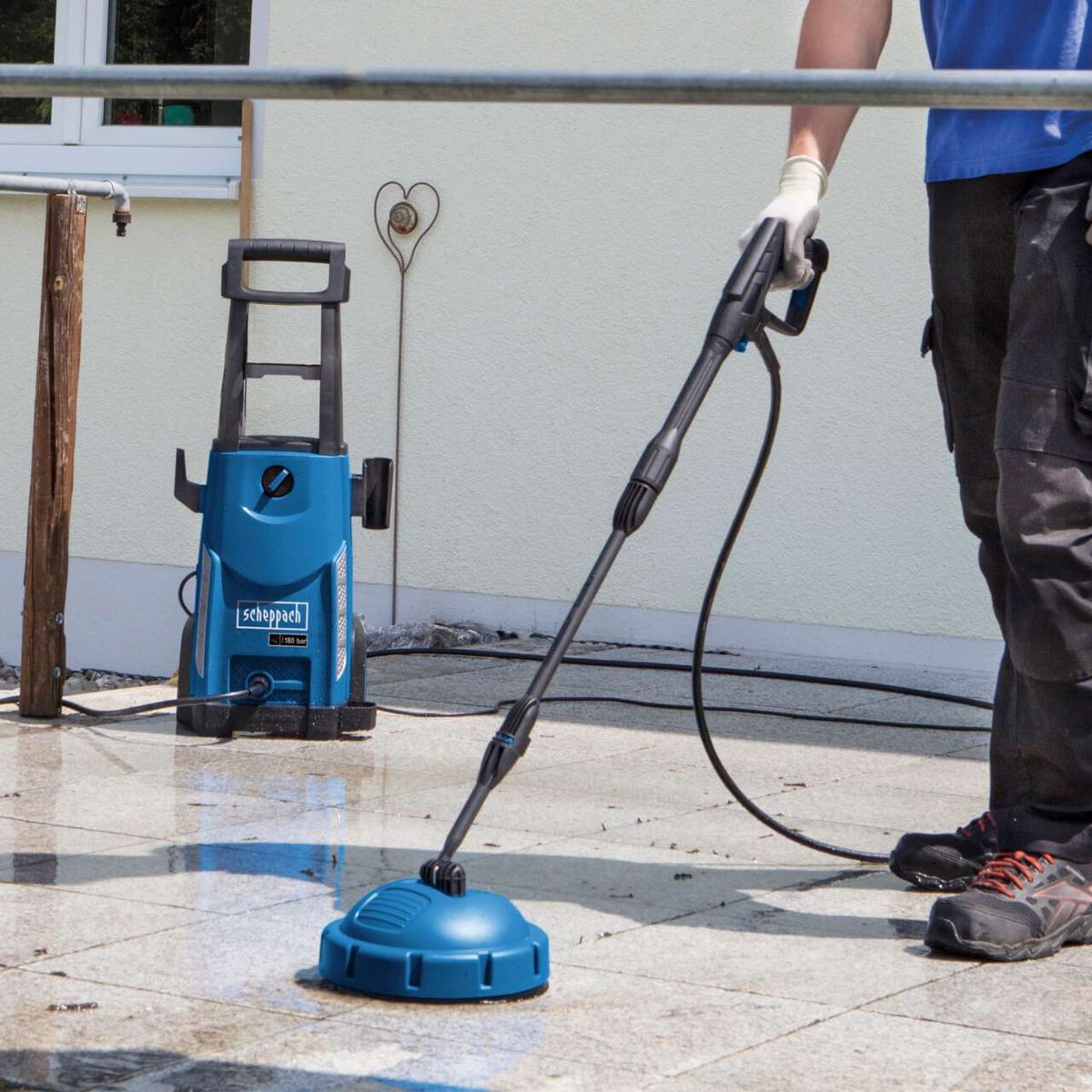 Pressure washer with hose and handheld nozzle, featuring a hanging attachment with heart emblem
