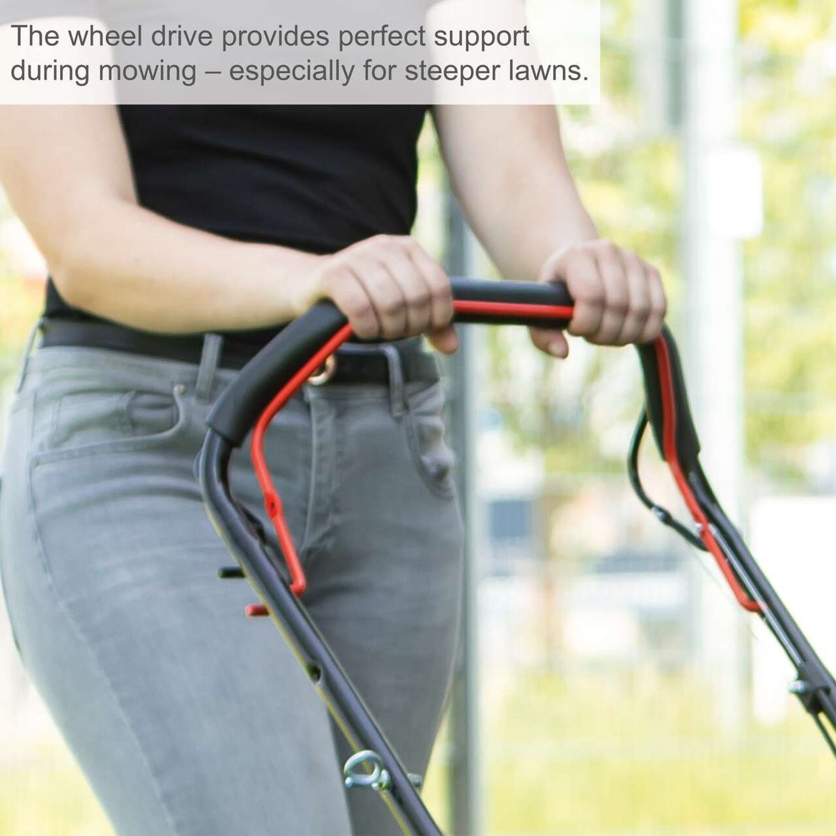 Person operating a Scheppach lawn mower with wheel drive during mowing