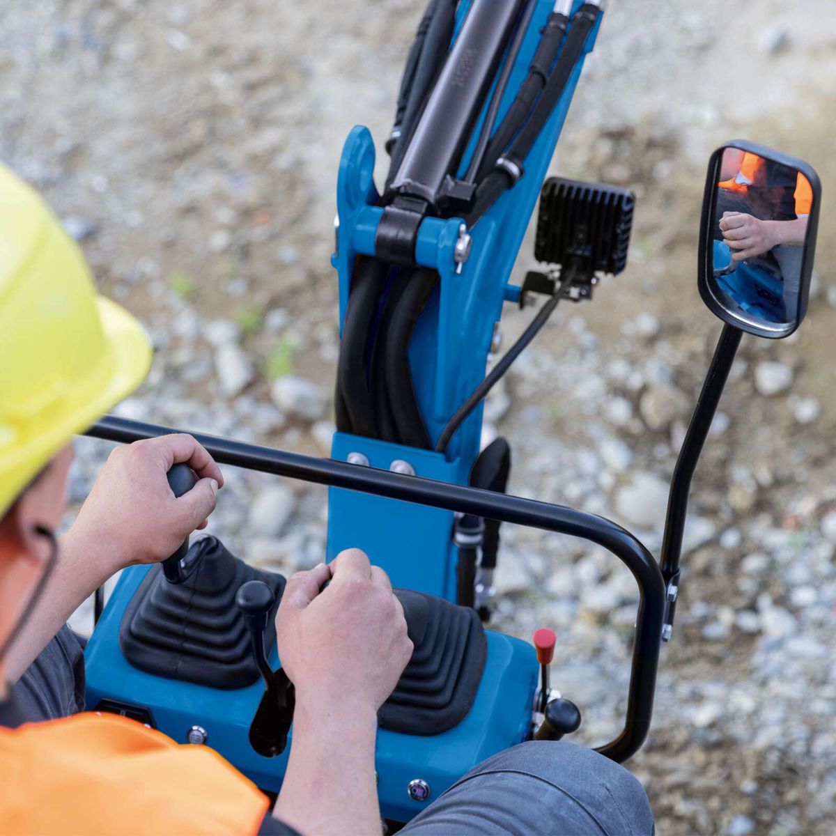 Compact excavator with ergonomic controls and arm for precise operation
