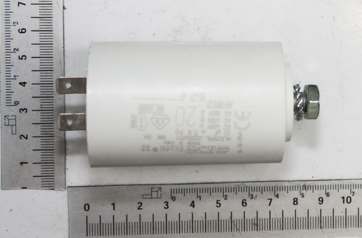 A capacitor labeled 40254003_Skala next to a ruler for size reference. The capacitor is shown from the side.
