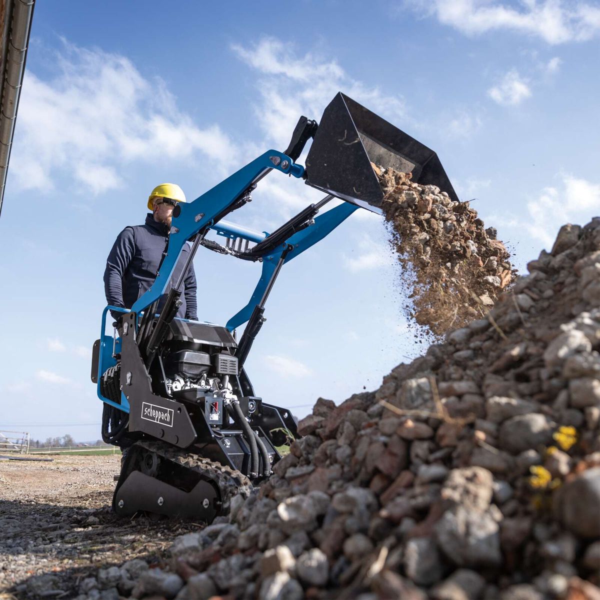 Scheppach loader with arm extending to move materials
