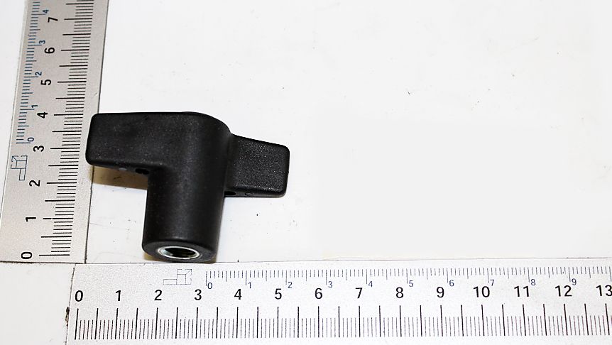 A black elbow connector with one straight and one angled end, next to a ruler for size reference. The elbow connector is approximately 3 cm long and 2 cm wide. The view shows the top of the elbow connector.