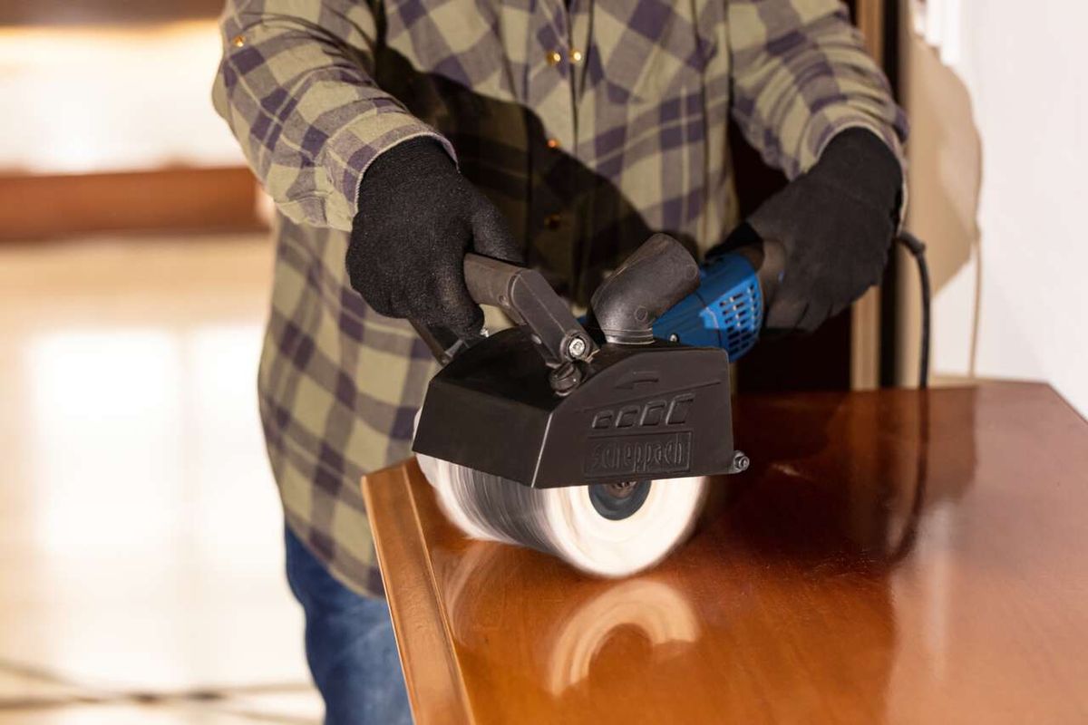 Person operating a Scheppach tool brush with gloves and protective gear