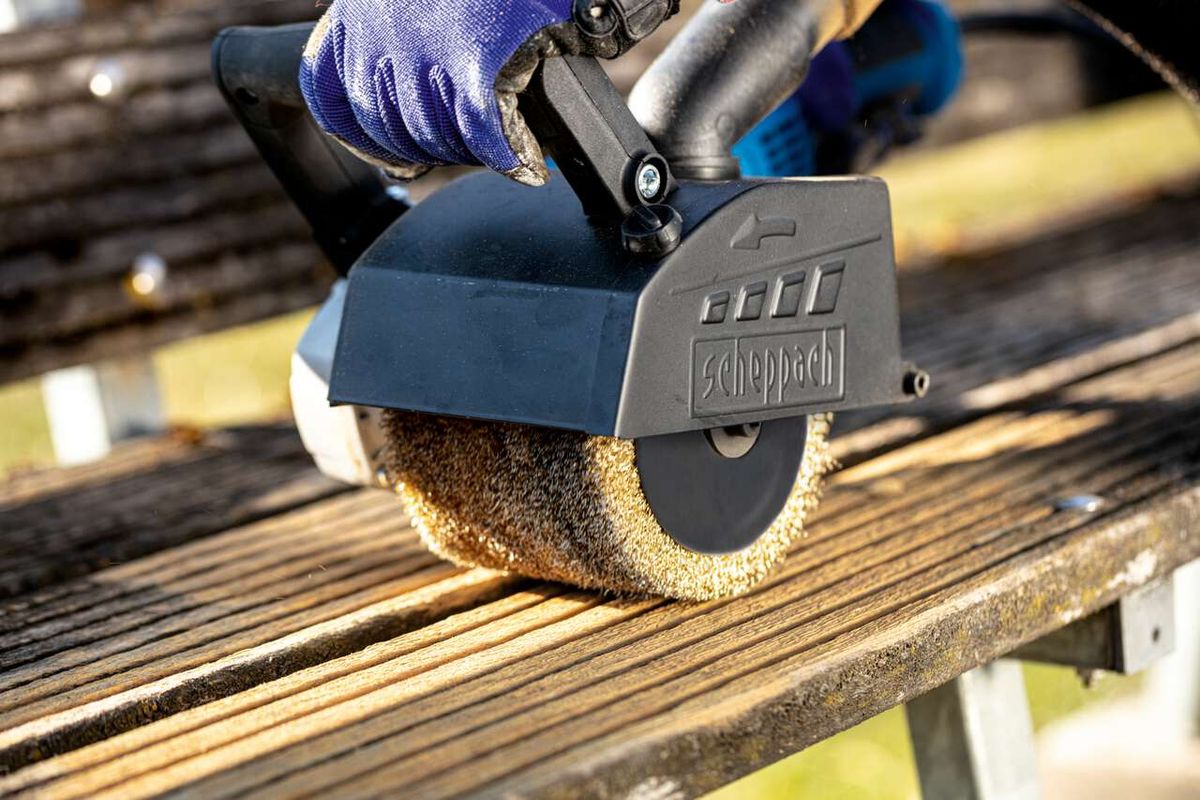 Scheppach metal wire brush in use on a machine. The brush is applied to wood.