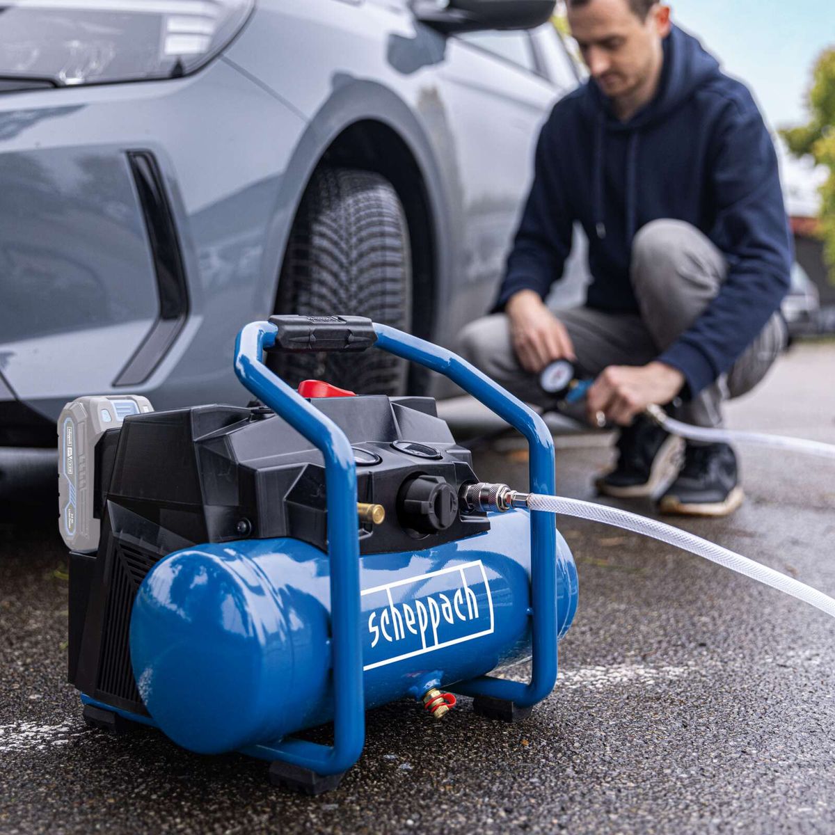 Scheppach cordless air compressor with tool attachment, handle, and hose