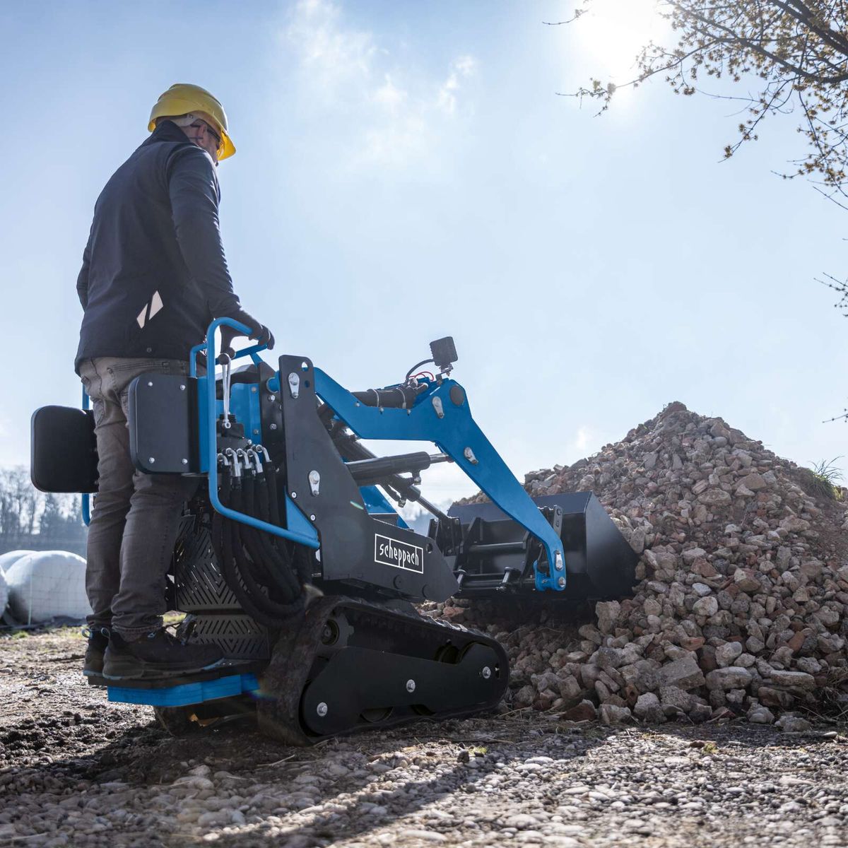 Scheppach skid steer loader with attached bucket, used for material handling and transport operations.