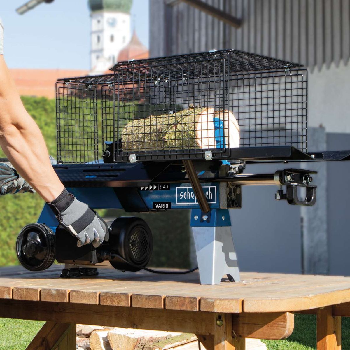 Log splitter with integrated transport basket for wood pieces, shown on the machine